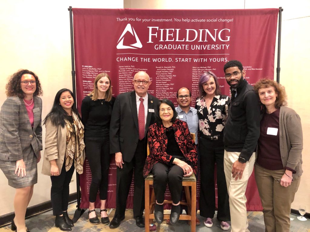 8 people flanking Dolores Huerta in front of Fielding banner