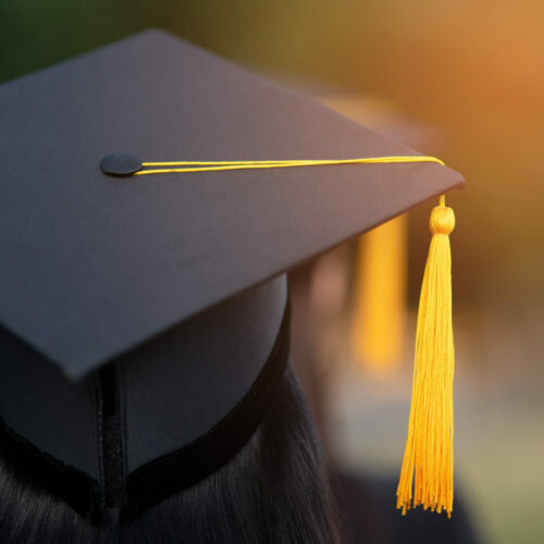 Back portrait of graduated wearing a black hat.